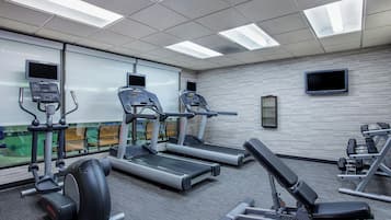 A gym with treadmills, a weight bench, and exercise machines.