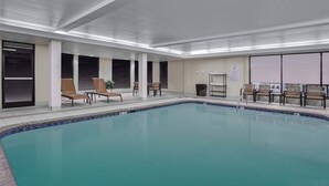 An indoor swimming pool with lounge chairs and tables, large windows, and a tiled floor. - Courtyard by Marriott Knoxville Cedar Bluff (Knoxville)
