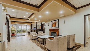 A lobby with a fireplace, seating area, and a reception desk.