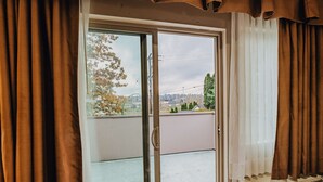 A room with a sliding glass door leading to a balcony.
