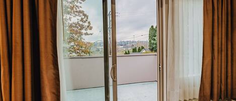 A room with a sliding glass door leading to a balcony.