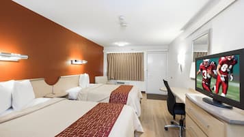 Una habitación de hotel con dos camas, un escritorio, un televisor y un espejo.