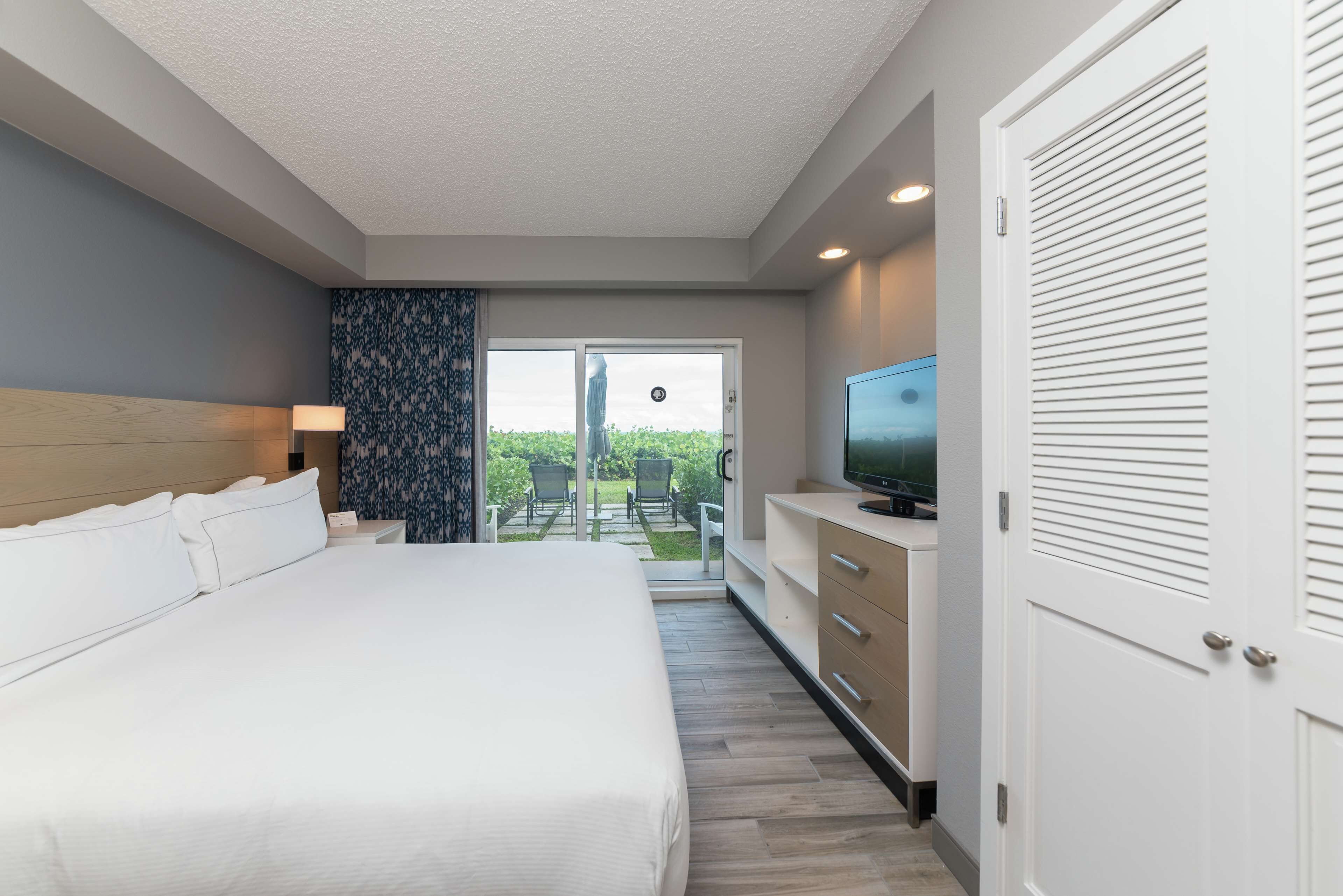 Une chambre d’hôtel avec un grand lit, une télévision, un bureau et une vue sur l’extérieur.