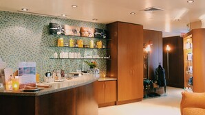 Eine Hotelhalle mit einer Rezeption, Holzschränken, einer Wand mit Kacheln und einer Sitzecke.