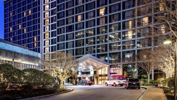 Ein Marriott Hotel mit moderner Fassade, mehreren Etagen und einem überdachten Eingangsbereich.