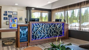 A reception area with a modern design, including a geometric wall panel, a reception desk, and a welcome sign. - Best Western Atlanta-Marietta Ballpark Hotel (Marietta)
