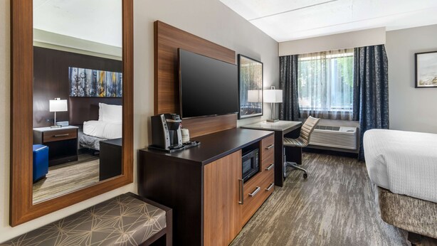 A hotel room with a large bed, a desk with a flat-screen TV, a coffee maker, a microwave, and a large mirror. - Best Western Atlanta-Marietta Ballpark Hotel (Marietta)