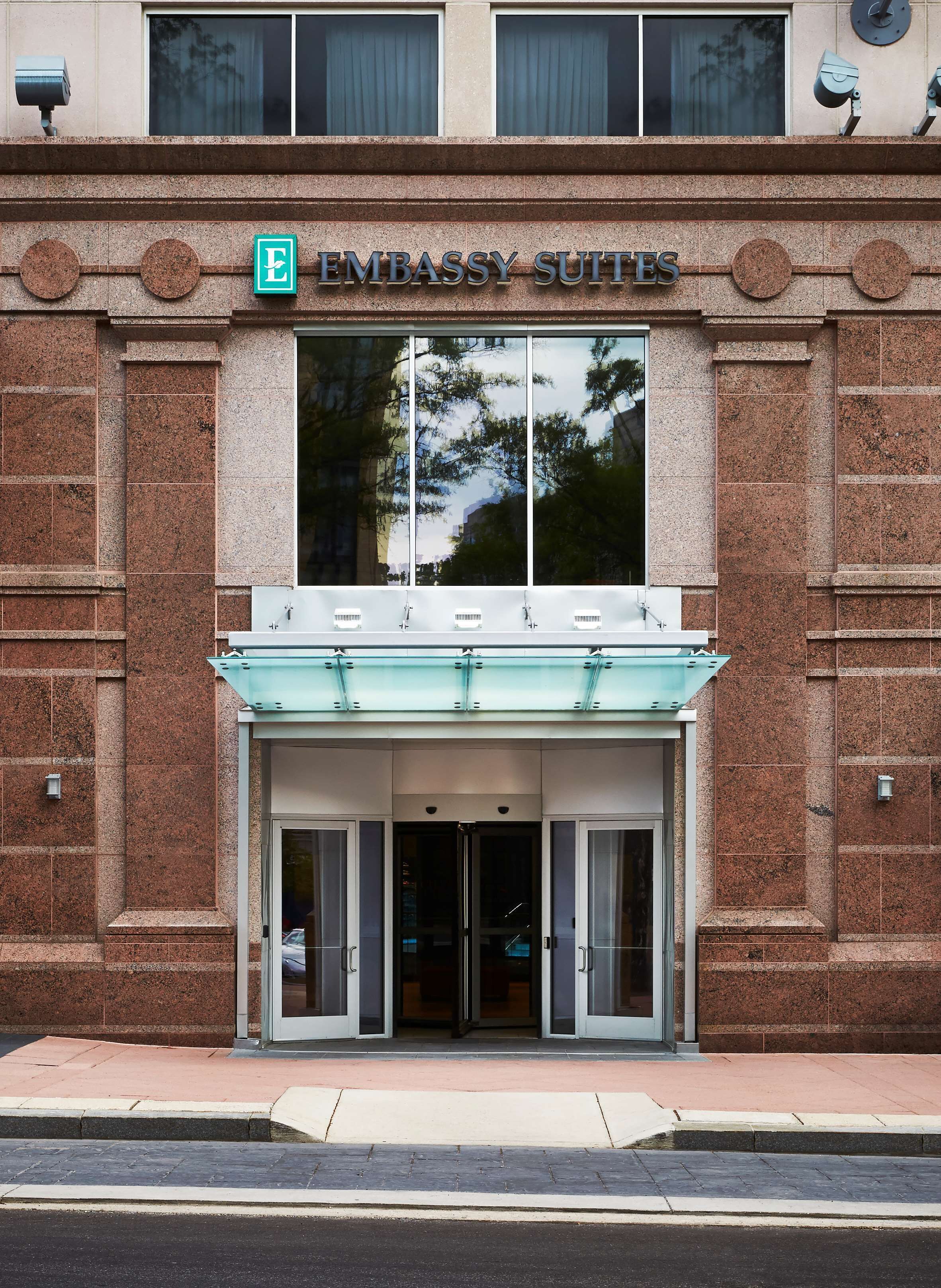 Fasaden på Embassy Suites har en framträdande entré, stora fönster och en skylt ovanför dörrarna.