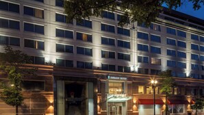 A multi-story hotel with a modern facade, large windows, and a prominent entrance with a red awning. - Embassy Suites by Hilton Washington DC Chevy Chase Pavilion (Washington)