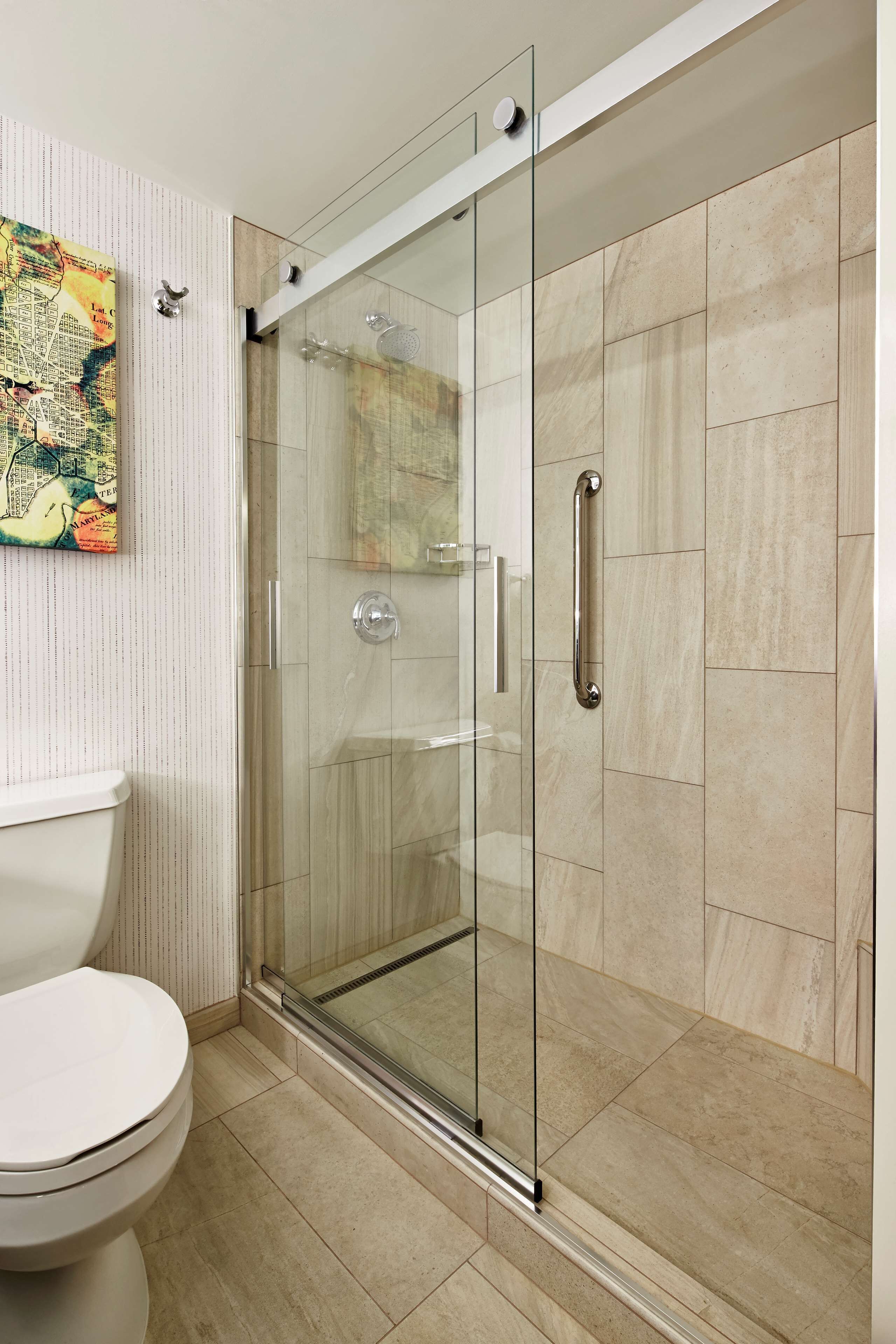 Une salle de bain moderne avec une douche à parois de verre, des toilettes et un élément décoratif mural.