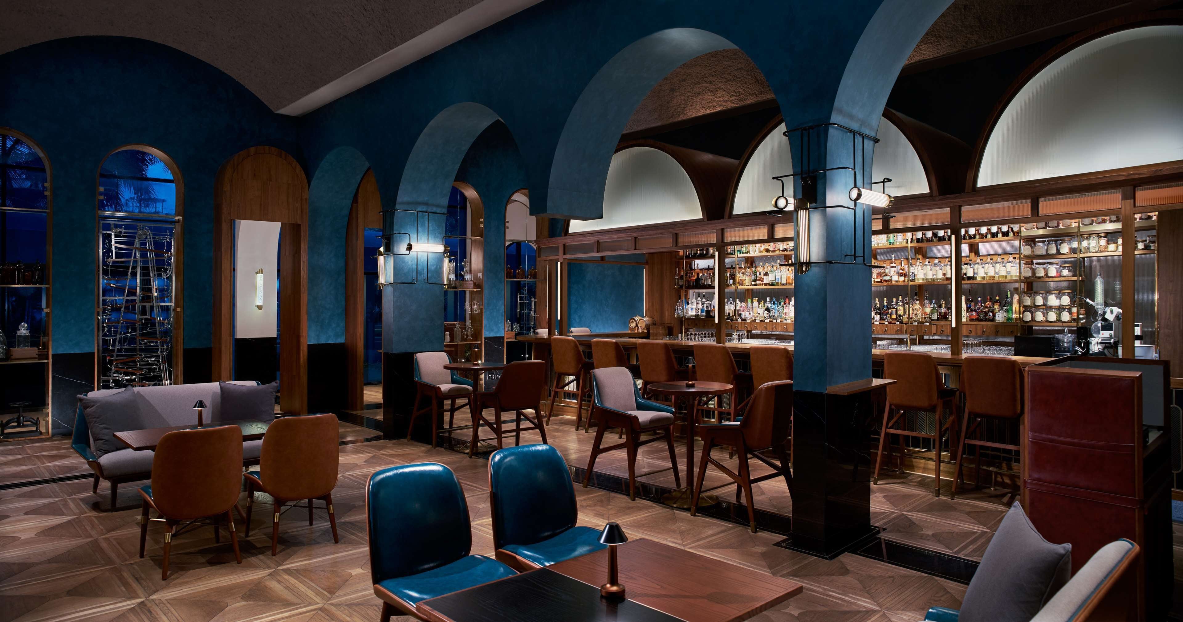 A bar area with wooden furniture, a bar counter, and shelves with bottles.