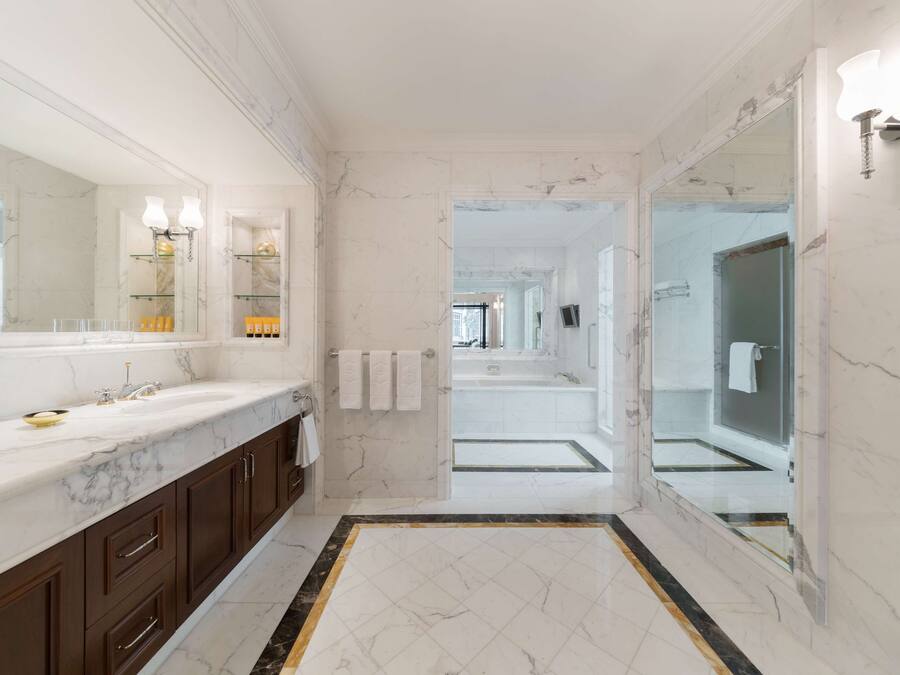 Un baño lujoso con encimeras de mármol, un espejo grande y un diseño moderno.