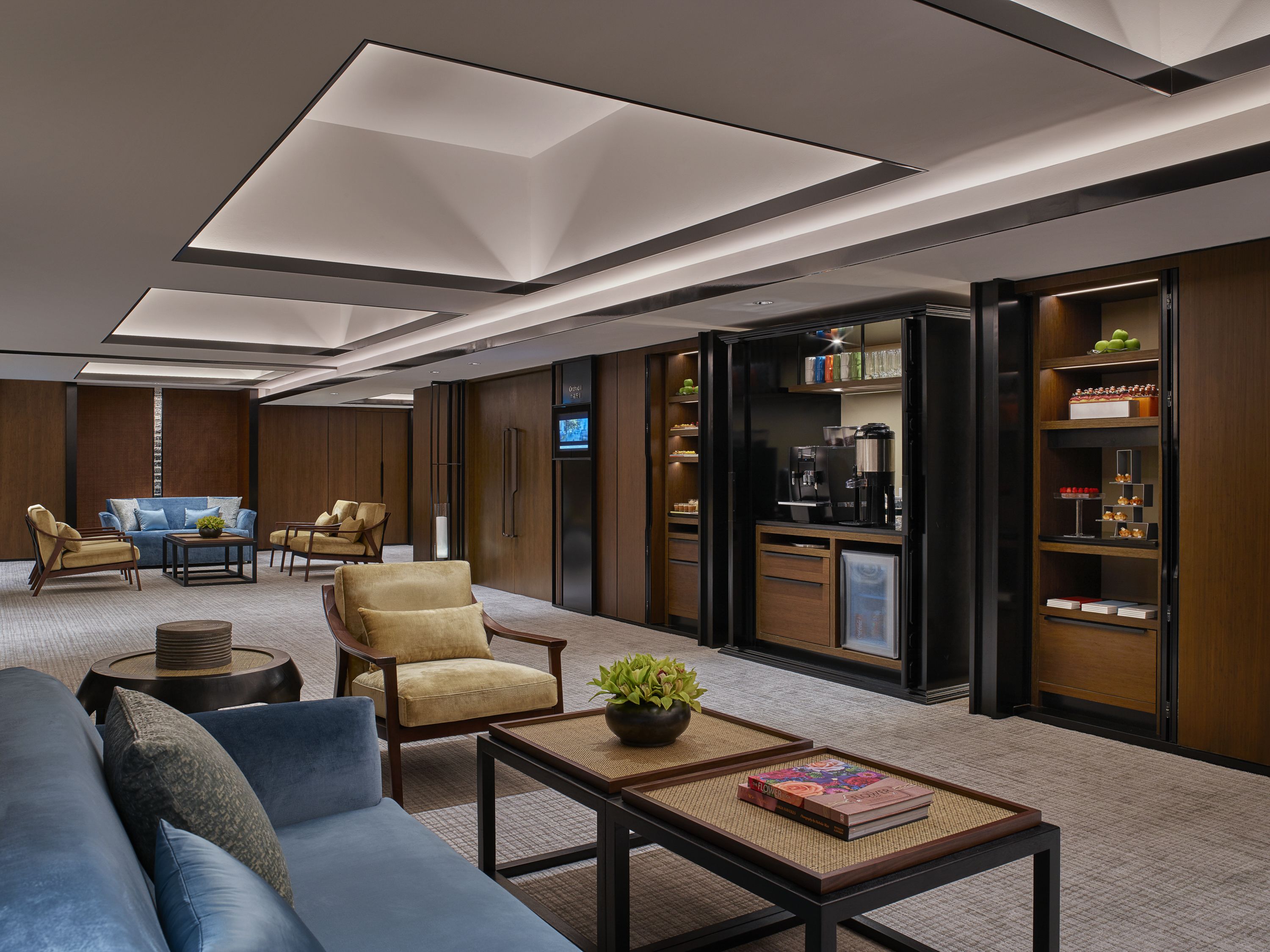 A modern living room with a sofa, armchairs, a coffee table, and a television.