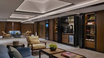 A modern living room with a sofa, armchairs, a coffee table, and a television.