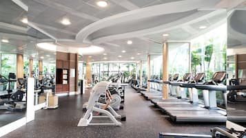 A modern gym with treadmills, ellipticals, and free weights.