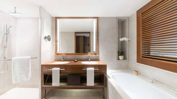 Un bagno moderno con due lavabi, uno specchio grande, una doccia e una vasca da bagno.
