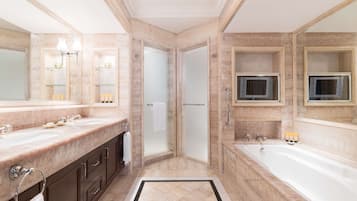A modern bathroom with a large bathtub, a glass-enclosed shower, and a vanity with a double sink.