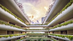 Un atrium à plusieurs niveaux, doté de balcons couverts de verdure, d’un espace central ouvert et offrant une vue sur le ciel.