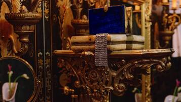 An ornate mirror with a decorative stand, a blue cloth, and brass containers.