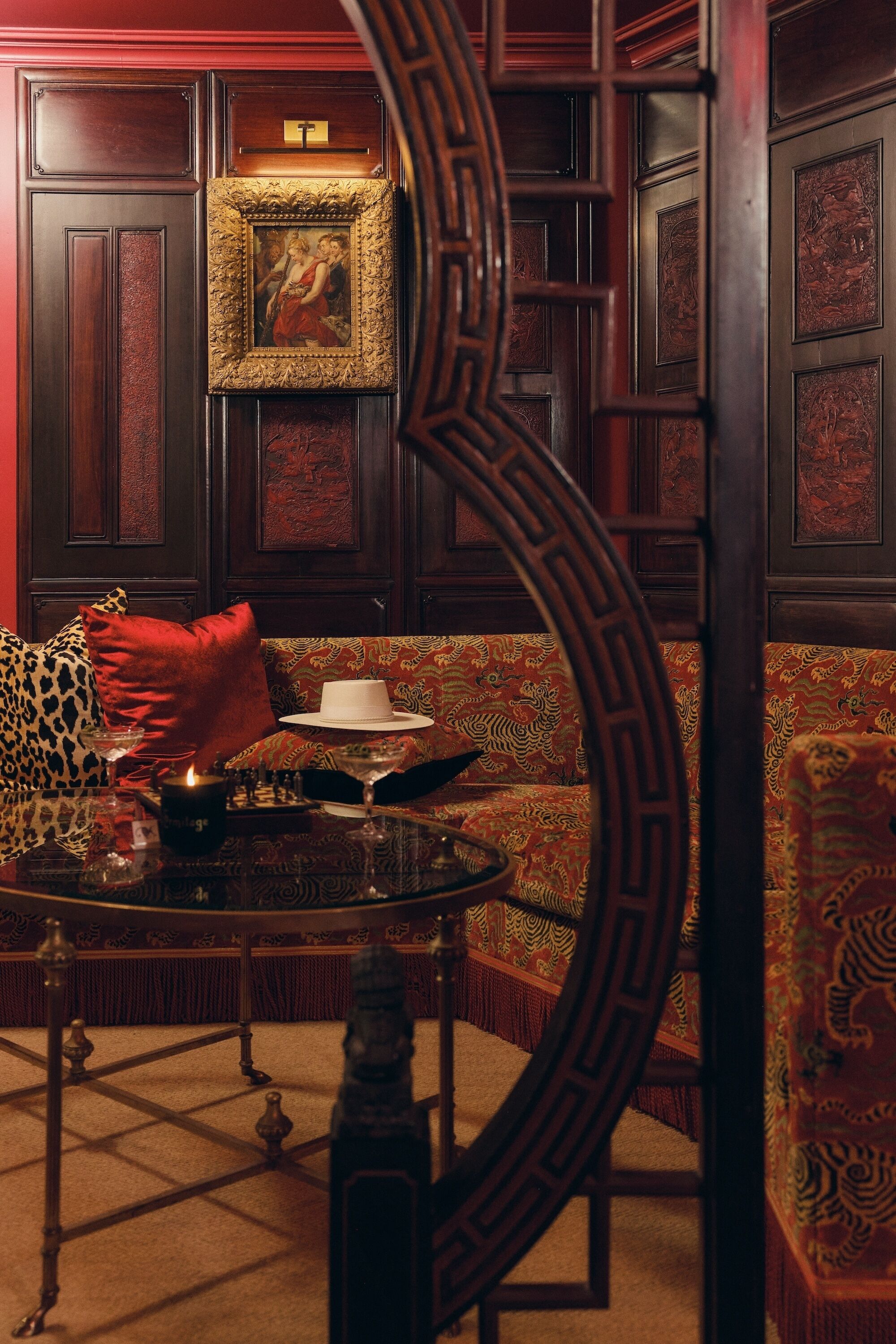 Una habitación con un sofá estampado, una mesa con una vela y un cuadro en la pared.