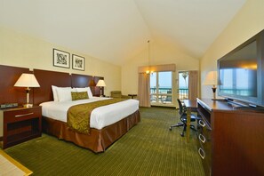 A hotel room with a large bed, two bedside tables with lamps, a desk with a chair, a television, and a balcony with a view. - Best Western Plus Dana Point Inn-by-the-sea (Dana Point)