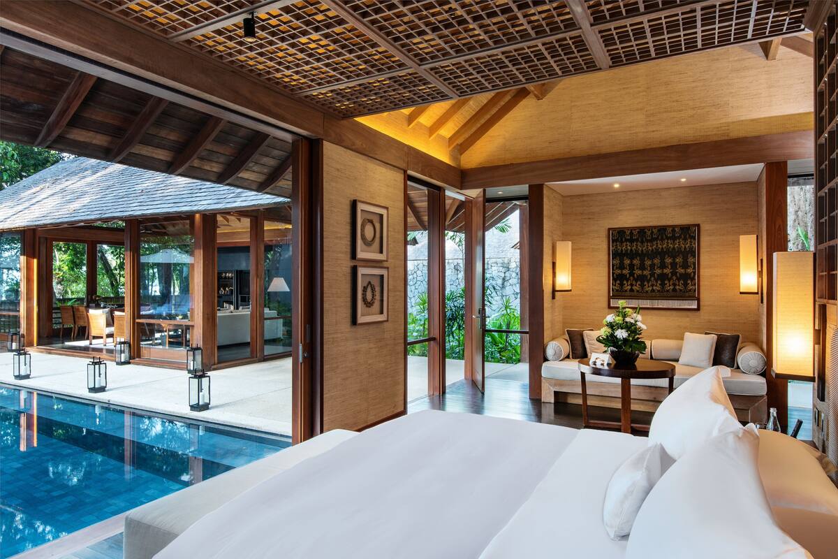 Ein modernes Hotelzimmer mit einem großen Bett, einem Pool und einem Essbereich mit Außenbestuhlung.