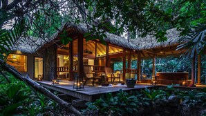 A thatched-roof structure with a wooden deck, surrounded by lush greenery. - The Datai Langkawi (Langkawi)