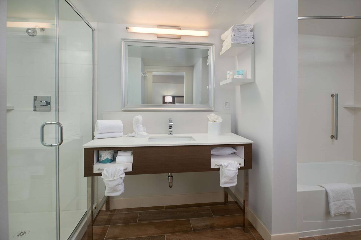 suite, 1 king bed, refrigerator & microwave (wet bar) | bathroom | combined shower/bathtub, free toiletries, towels