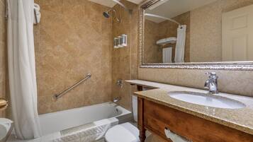 Un baño con bañera, inodoro y lavamanos.