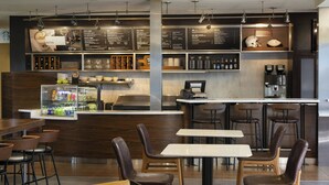A modern bistro with a bar area, seating arrangements, and a menu display. - Courtyard by Marriott Fresno (Fresno)