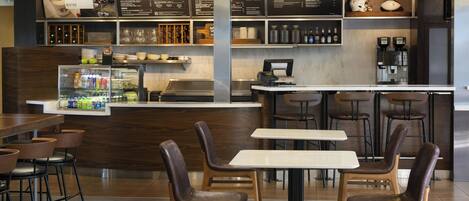 A modern bistro with a bar area, seating arrangements, and a menu display.