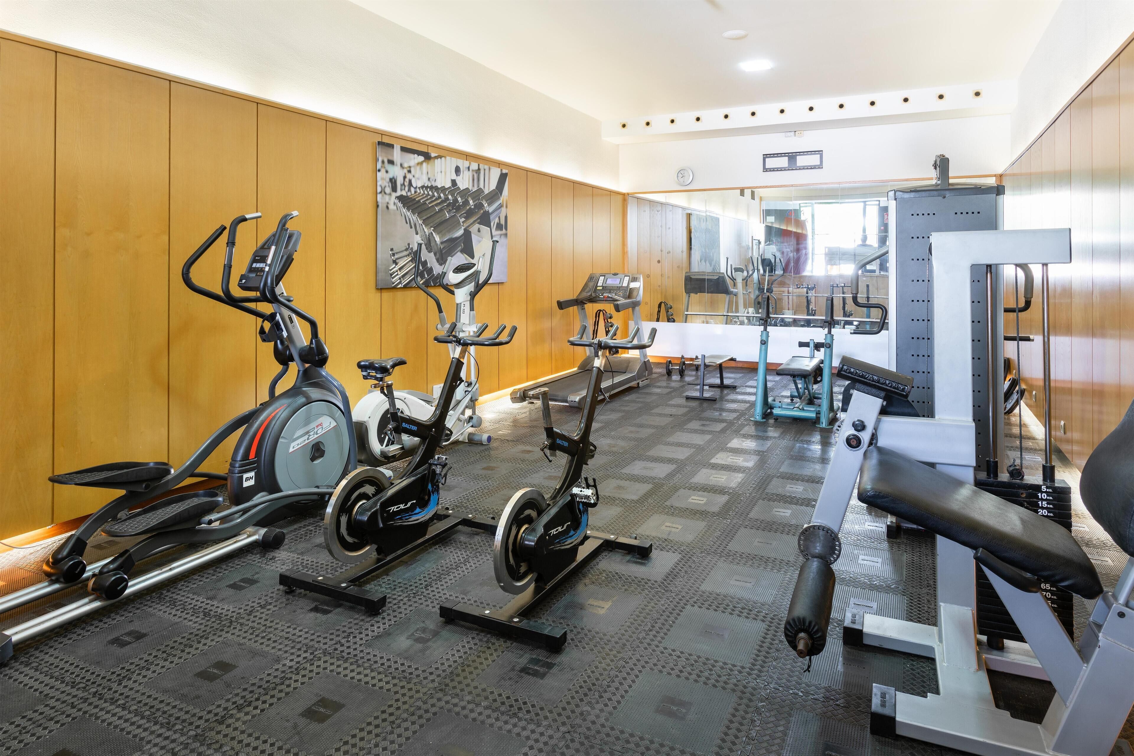 A gym with stationary bikes, a treadmill, and weight machines.