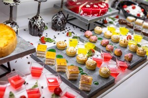 Variedad de postres y bebidas a la vista, como pasteles, tartas y coloridas bebidas.