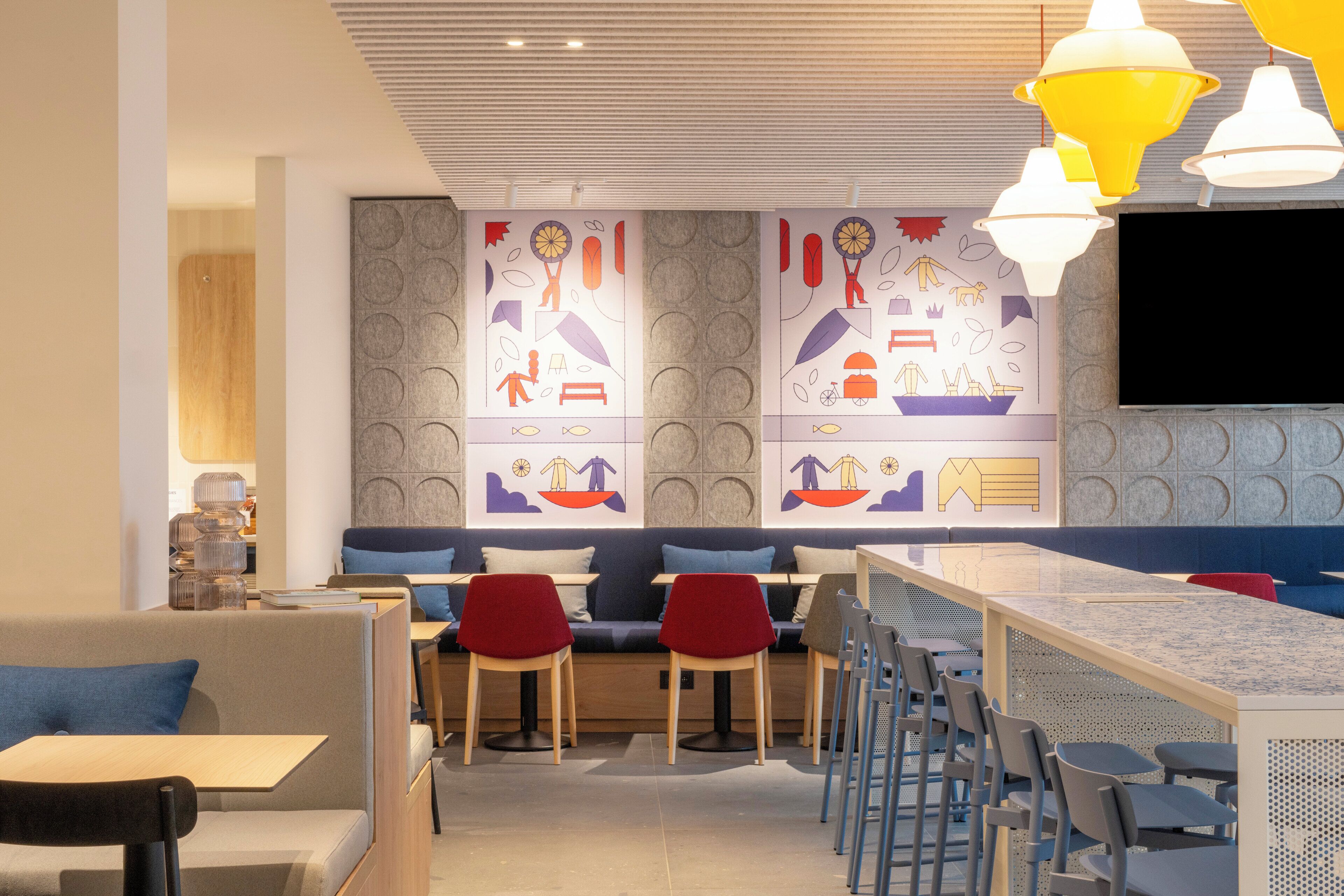 Un restaurant moderne doté d’un long comptoir, de banquettes et de chaises hautes.