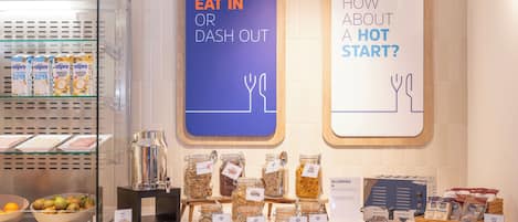 Una barra de desayuno con diferentes opciones de comida y un letrero que dice "EAT IN OR DASH OUT".