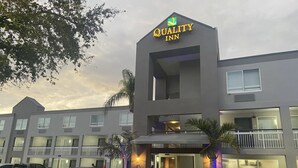 A hotel with a sign reading "Quality Inn" and a modern architectural design.