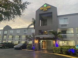 Un hotel con una insegna che recita "Quality Inn" e un design architettonico moderno.