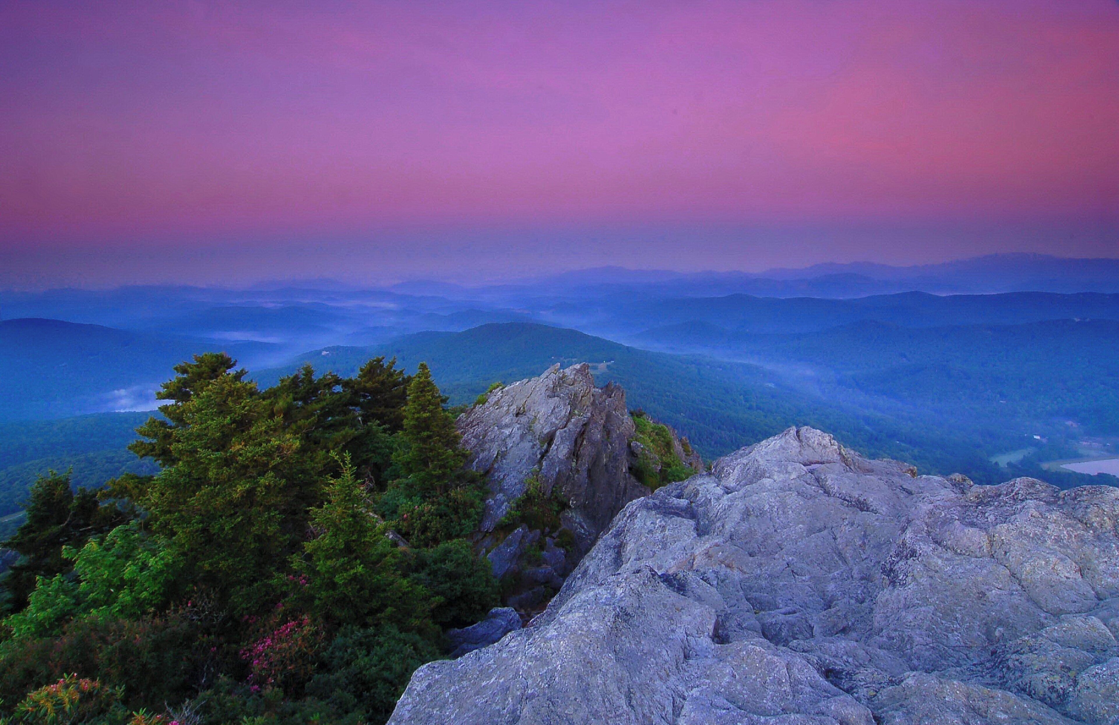 A mountainous landscape with rocky outcrops and dense forest.