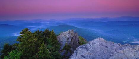 A mountainous landscape with rocky outcrops and dense forest.