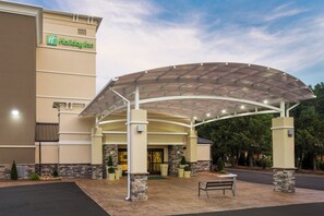 A Holiday Inn hotel entrance with a covered patio area and stone pillars.