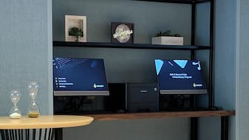 A modern room with a desk, two monitors, a small plant, and decorative items.