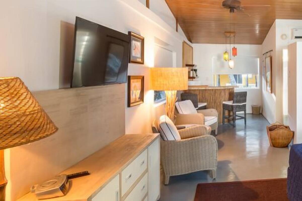 Ein Hotelzimmer mit Bett, Schreibtisch, Stuhl, Lampe und Fernseher.