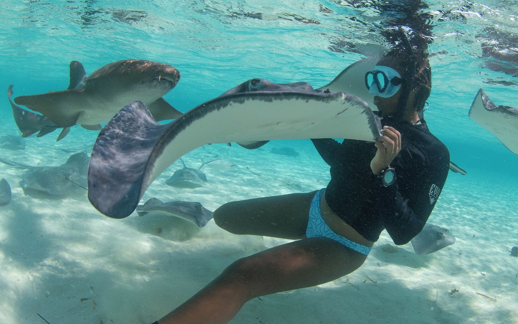 Un buceador bajo el agua con mantarrayas.