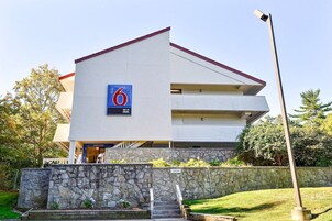Un motel moderno con un llamativo letrero con el número '6'.