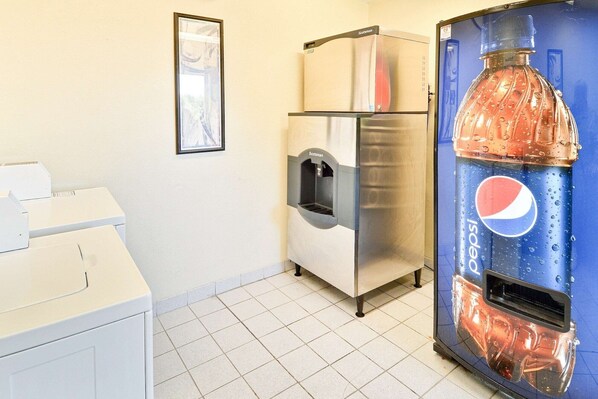 A kitchenette with a refrigerator, a water dispenser, and a large Pepsi refrigerator.