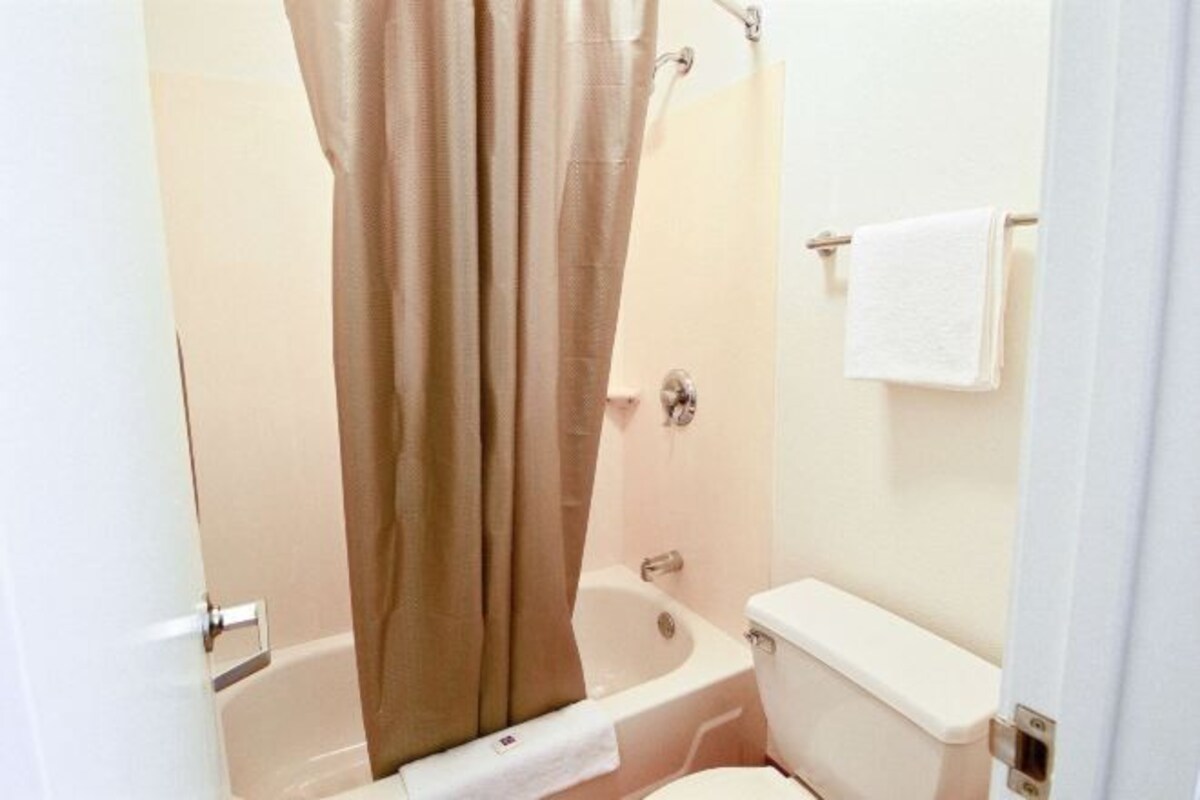 Een badkamer met een bad, toilet en een handdoekrek.