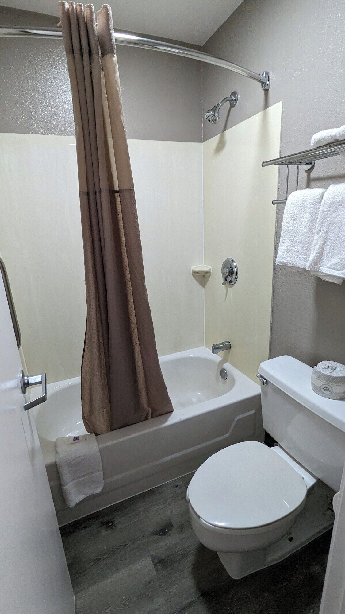 A bathroom with a bathtub, toilet, and shower curtain.