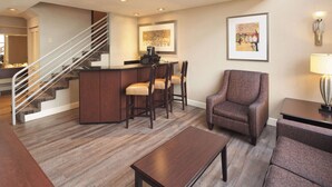 Un hall d’hôtel avec un escalier, un bar et des espaces pour s’asseoir.