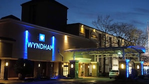 Un hôtel Wyndham doté d'une enseigne lumineuse bien visible, d'une entrée abritée et d'un espace de stationnement.