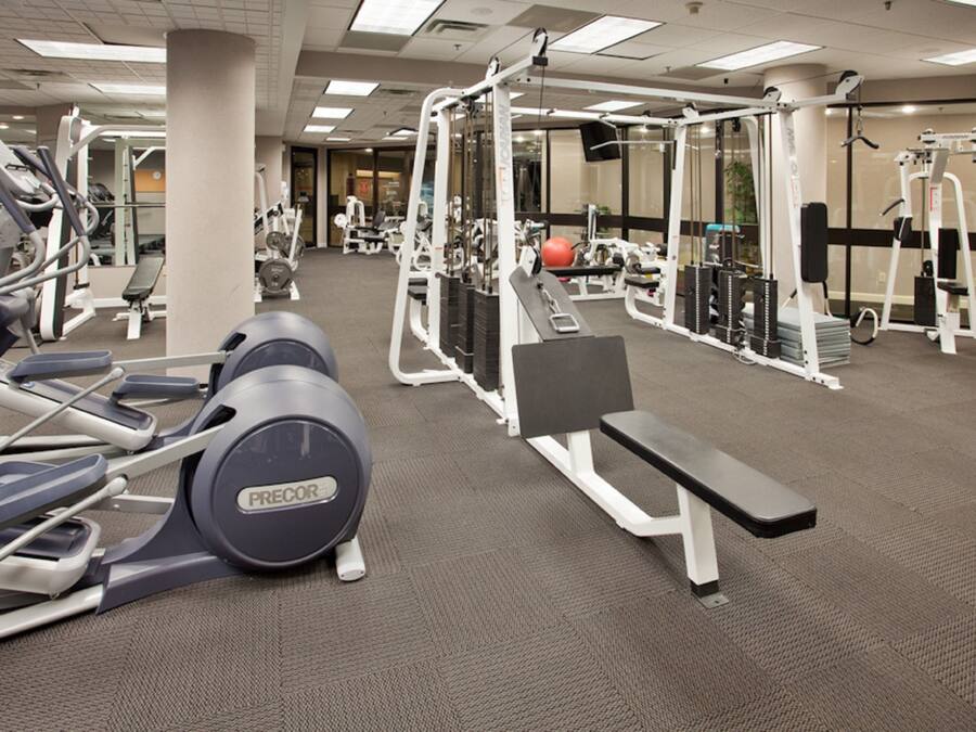 Une salle de sport équipée de divers appareils d’exercice, notamment des tapis de course et des appareils de musculation.